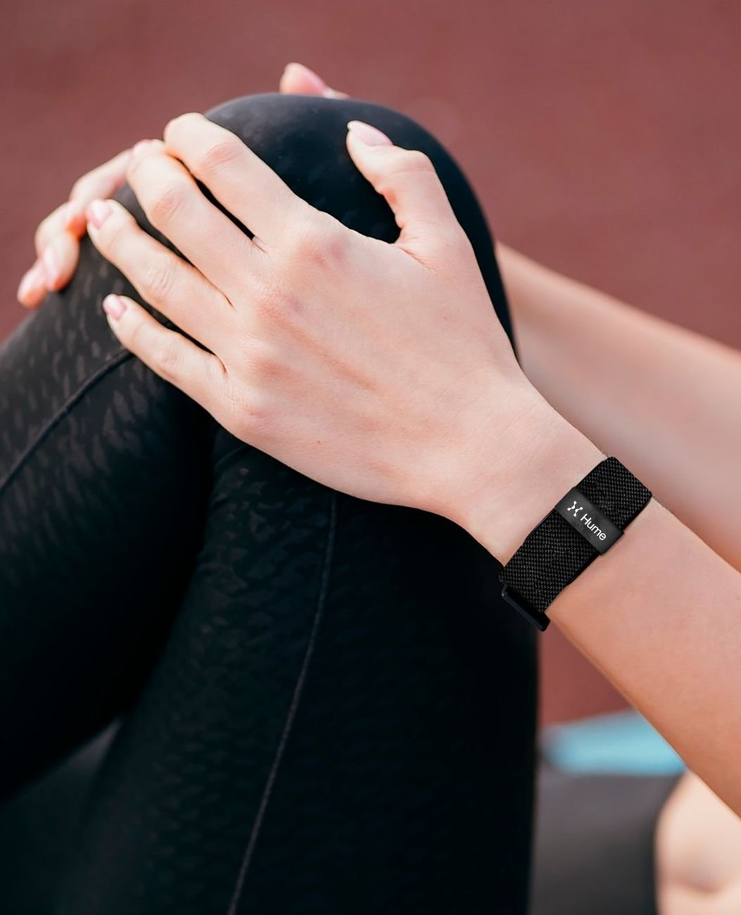 Close-up of hands with the Hume Watch on the wrist during a stretching routine